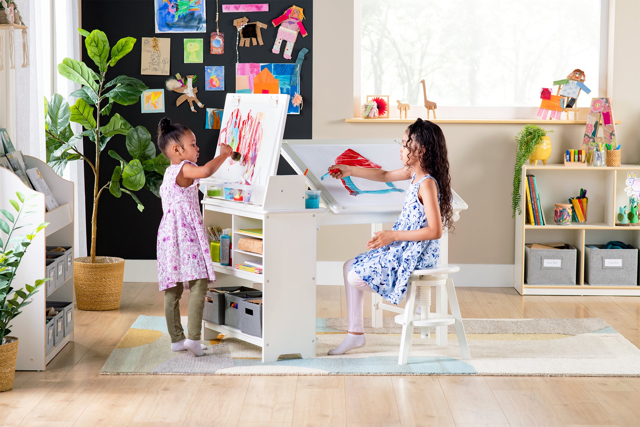 Two sisters sitting and drawing at the new design studio 3 in 1 art table. Click to shop all art tables and storage