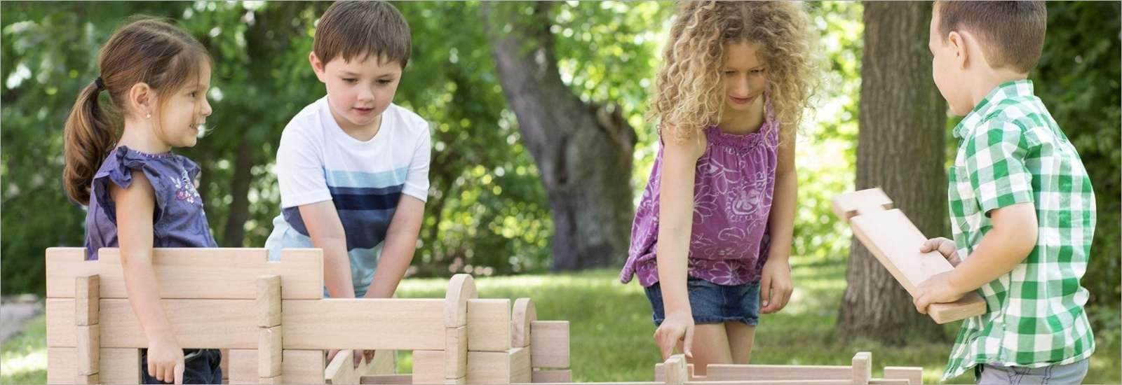Children playing outside with guidecraft toys