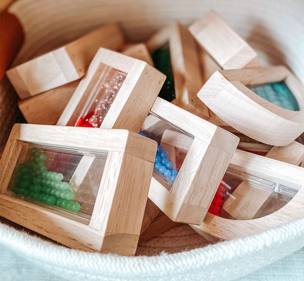 Close up detailed view of a soft woven basket full of wood blocks with assorted sensory components in the middle of each