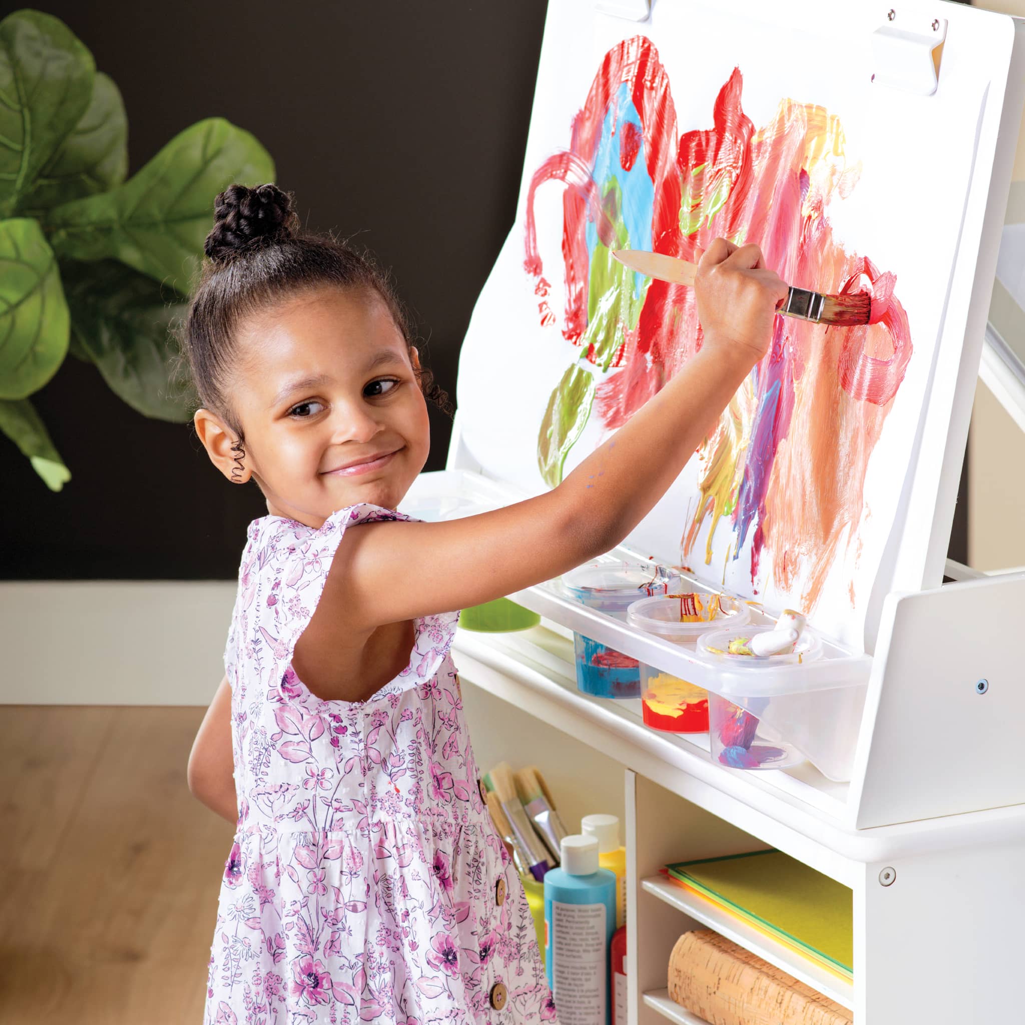 Young girl painting at the easel adjustment of the Guidecraft 3-in-1 Design Studio