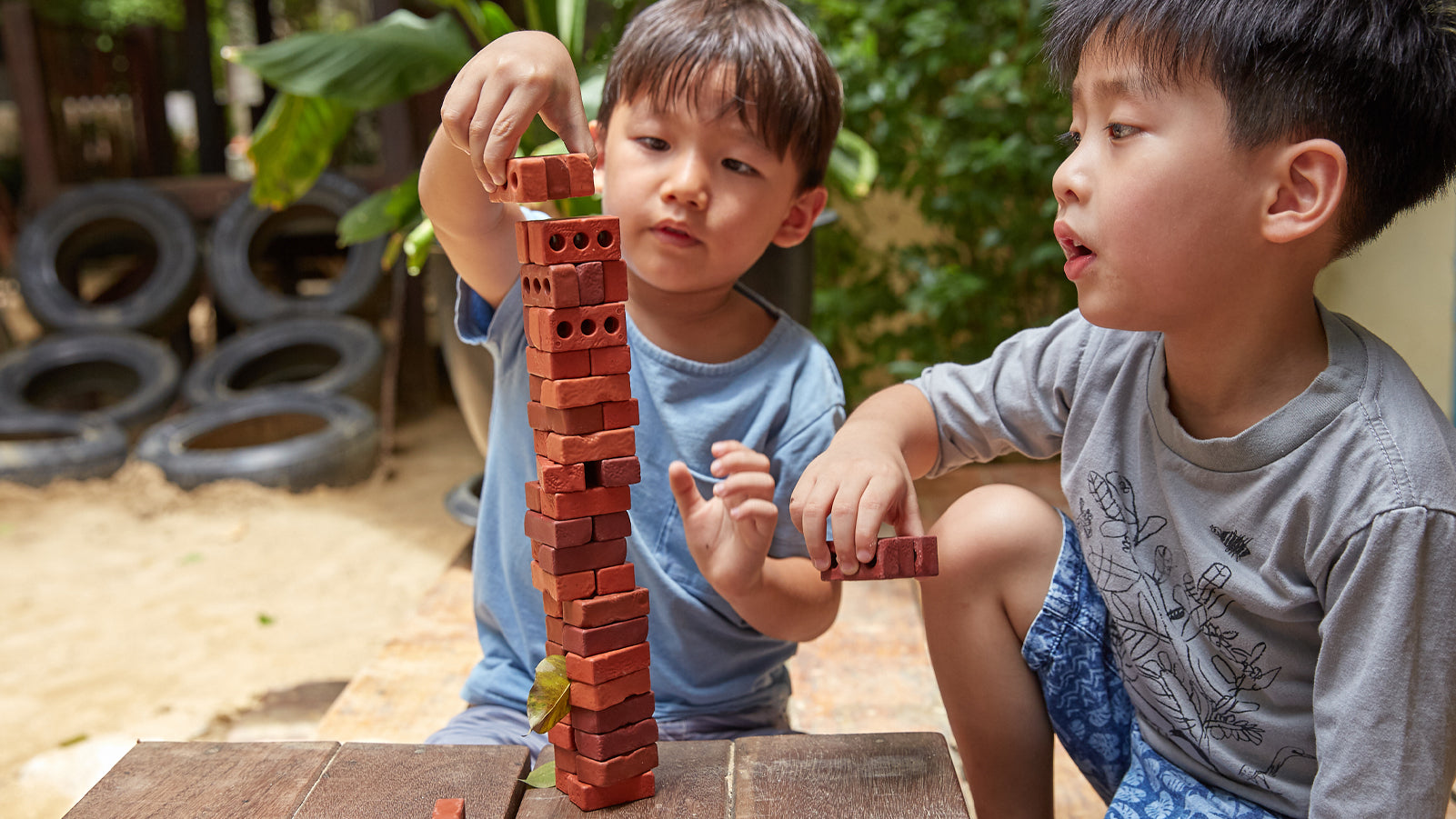Two preschool aged boys building with Guidecraft Little Bricks Toy
