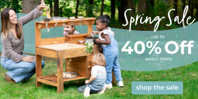Family playing with a wooden play kitchen set outdoors, with promotional text for a spring sale