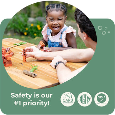 Child playing with building blocks at a table, with a person assisting, on a green background with safety certification logos. Click to shop the collection