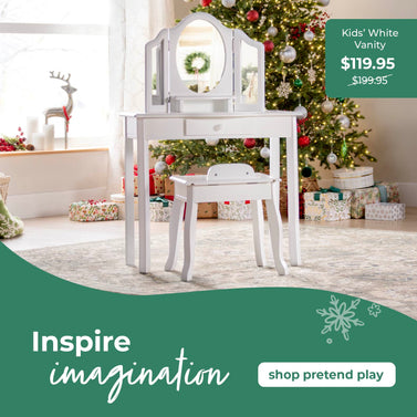 White vanity with mirror in a room decorated for Christmas, with text promoting the product. Click to shop ll pretend play furniture.
