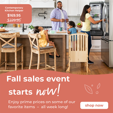 Family in a modern kitchen with the youngest child standing in a Guidecraft Contemporary Kitchen Helper Toddler Tower. Fall sales event text on an orange background