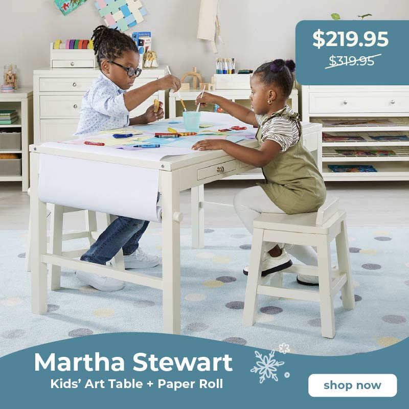 Two children playing at a Martha Stewart kids' art table with a paper roll in a room setting. Click to shop the art table for $100 Off