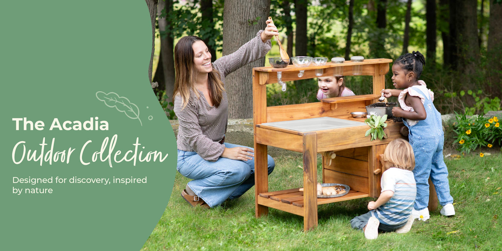 Children playing at a wooden play kitchen outdoors with a woman supervising, featuring the Acadia Outdoor Collection branding.