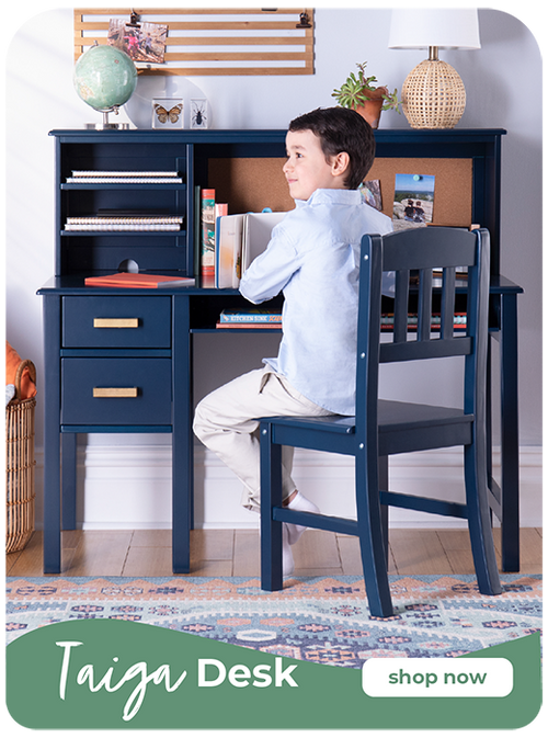 Young boy sitting in a stylish bedroom at his Navy Taiga Desk set