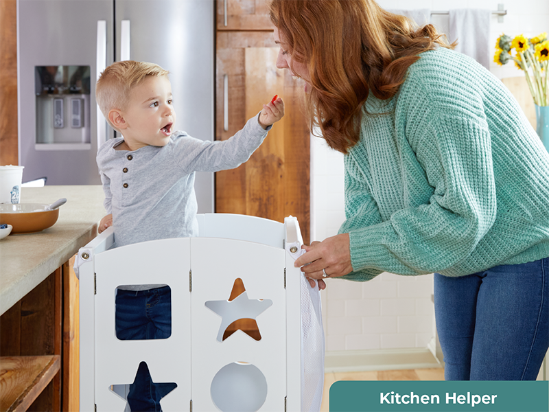 A mother and her son in their natural wood kitchen. Her son is using Guidecraft's Classic style Kitchen Helper. The title Kitchen Helper is visible.