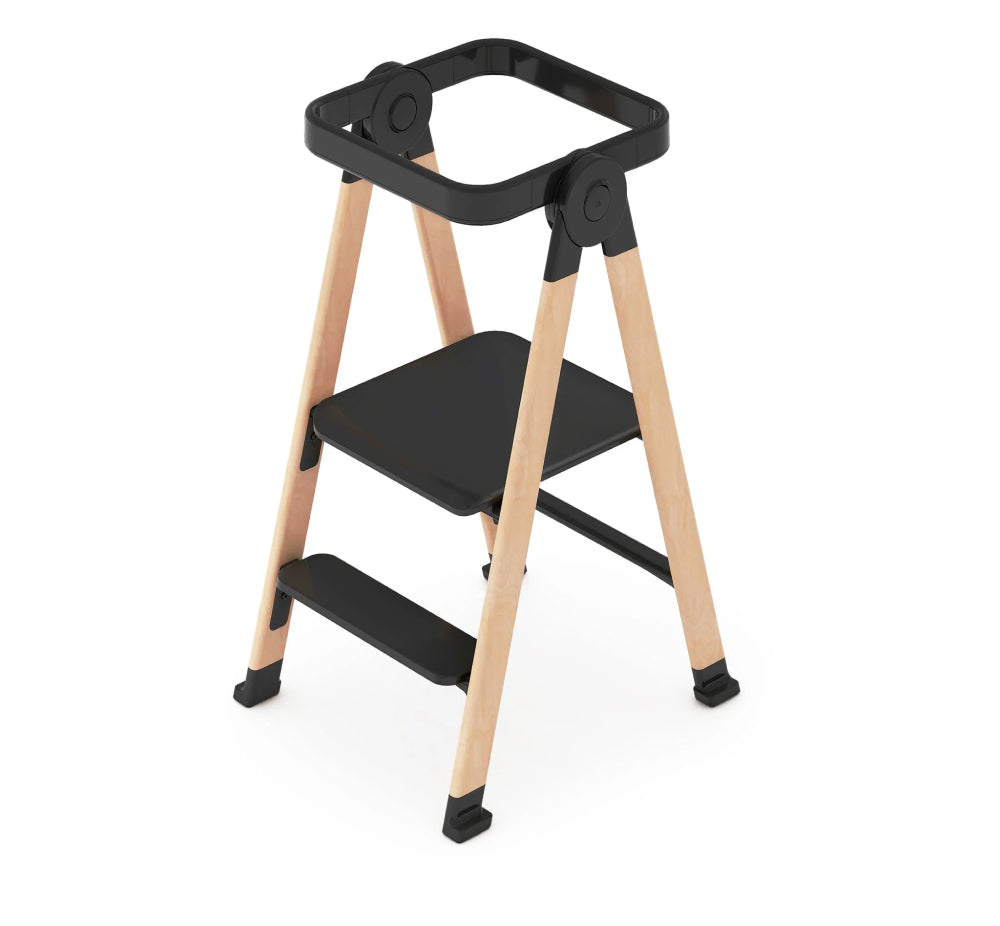 Step stool with black seat and wooden legs on a white background