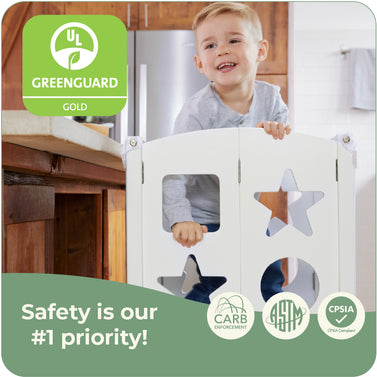 Image of happy child in kitchen helper and certification logos. The kitchen helpers are greenguard gold certified. They are designed and tested to meet or exceed international safety standards.