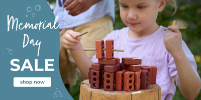 Child playing with a wooden toy stack outdoors, promotional text for Memorial Day sale