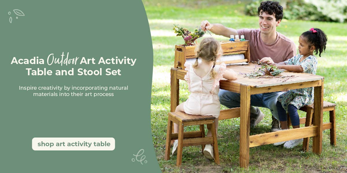 Two children and a adult sitting at an outdoor art activity table in a grassy area. Creating art on the Acadia Art Activity Table. Click to shop the art table.