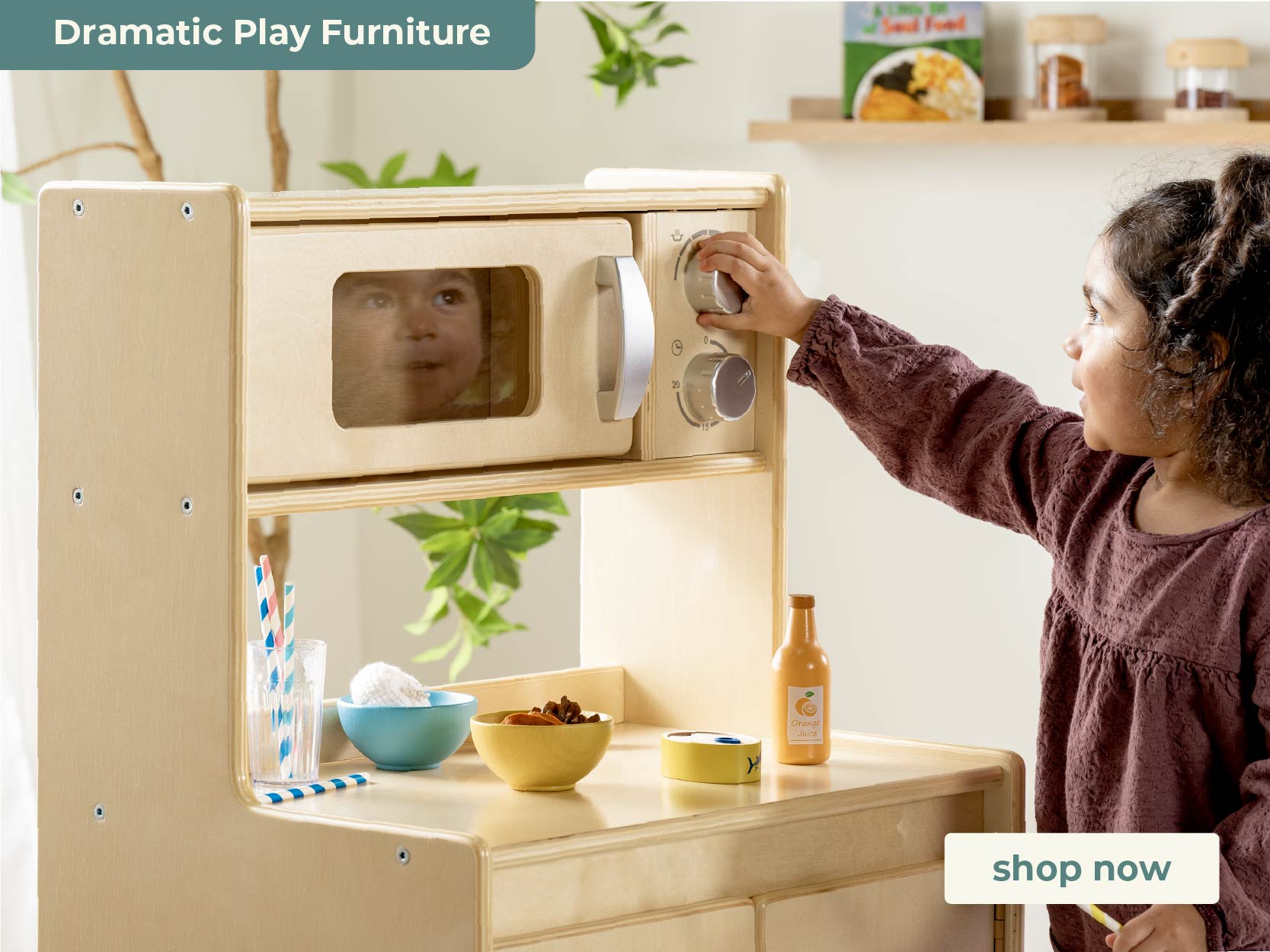 Child playing with a wooden play kitchen set, with a 'shop now' button visible.