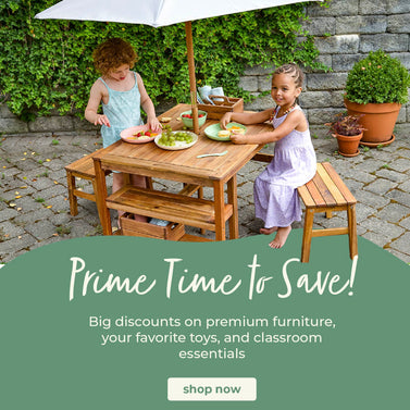 Two girls sitting at the Martha Stewart Crafting Table, click to shop all outdoor furniture