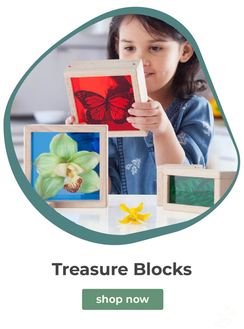 Child holding a framed picture of a butterfly with other framed pictures on a table, promoting 'Treasure Blocks'.