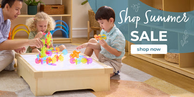 Children playing with colorful toys in a wooden play table, with a Shop Summer Sale