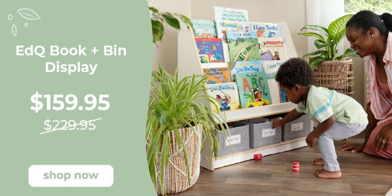 EdQ Book + Bin Display with children playing and a woman supervising, on a wooden floor with plants. Click to shop $70 off the book and bin display