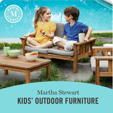 Children sitting on outdoor furniture with a pool in the background, featuring Martha Stewart Kids' Outdoor Furniture. Click to shop.