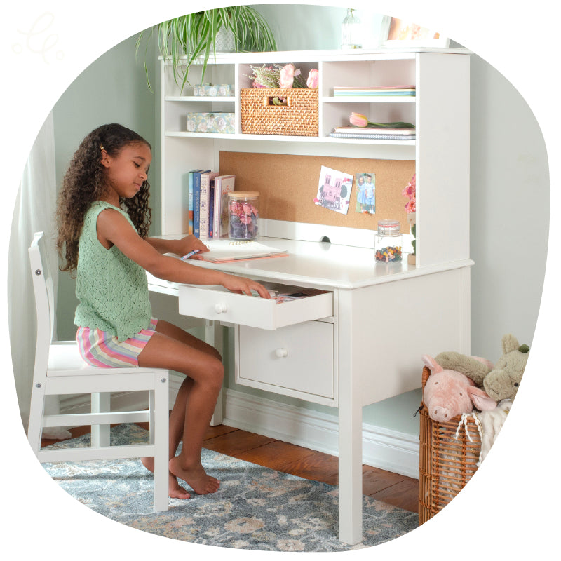 Young girl sitting at a Madison desk looking in the drawer