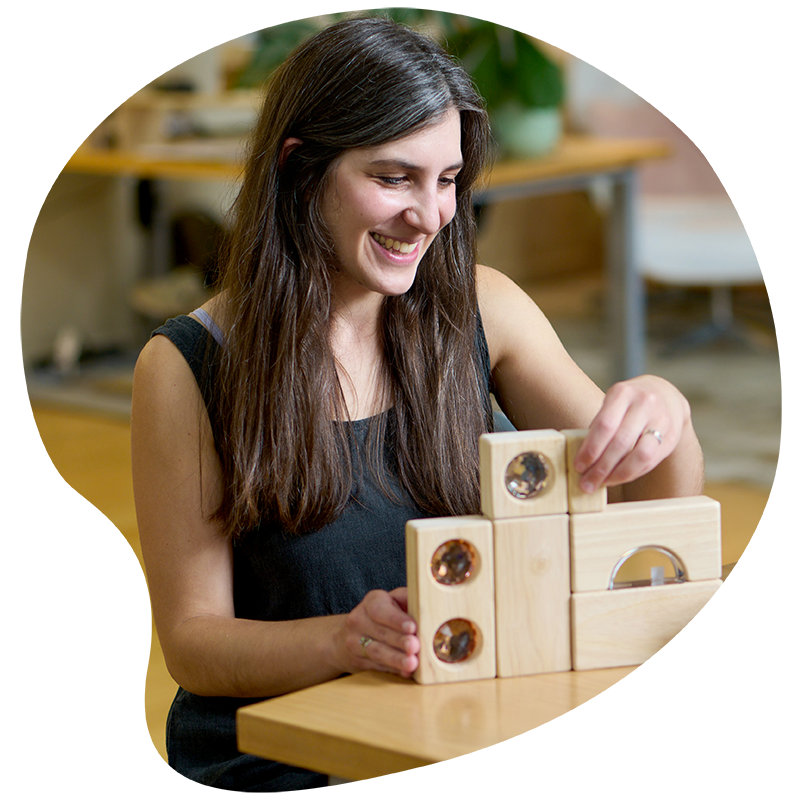 Portrait of a smiling Sami Krasny, Block Play Expert, arranging new unit block pieces to show they are mathematically aligned.