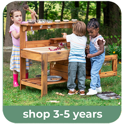 Three children playing with the Guidecraft Acadia Mud kitchen set on a grassy lawn, with a green banner at the bottom reading 'shop 3-5 years'.