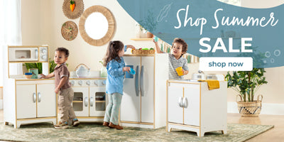 Children playing with a play kitchen set in a room with decorative elements.