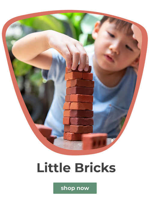 Young asian boy playing with little bricks in a lush outdoor scene