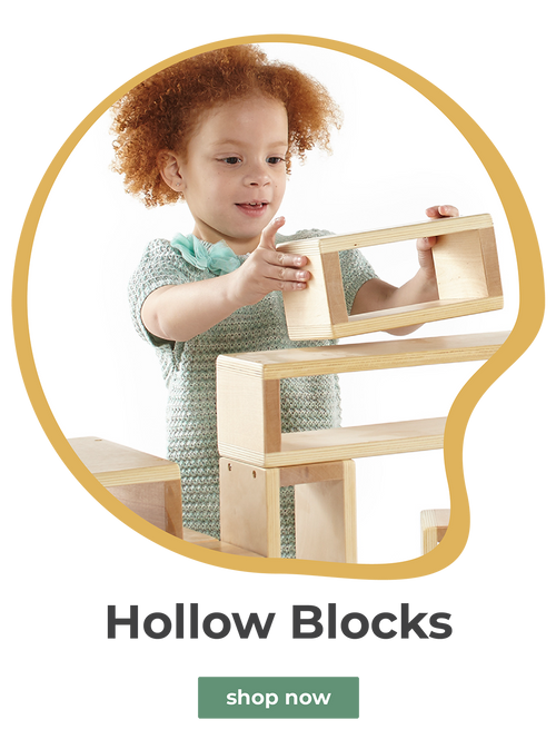 Young girl playing with large wooden hollow blocks