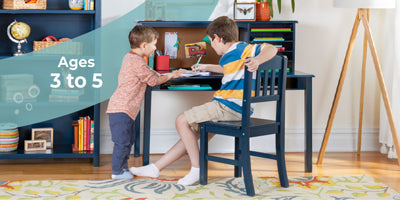 Two boys collaborate at a desk in a vibrant room with shelves; text reads Ages 6+, encouraging teamwork.