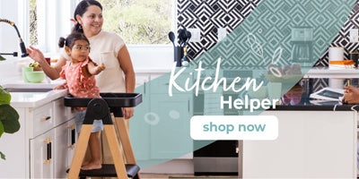 A woman and a young child stand in a bright kitchen next to a sturdy learning tower; text reads Kitchen Helper, shop now.
