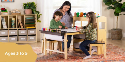Woman and two children at a wooden table with art supplies in a home setting.